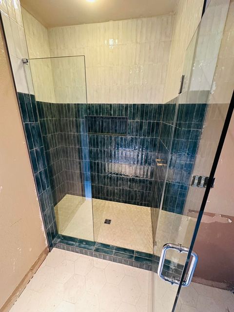 Deep green stacked tile behind frameless glass