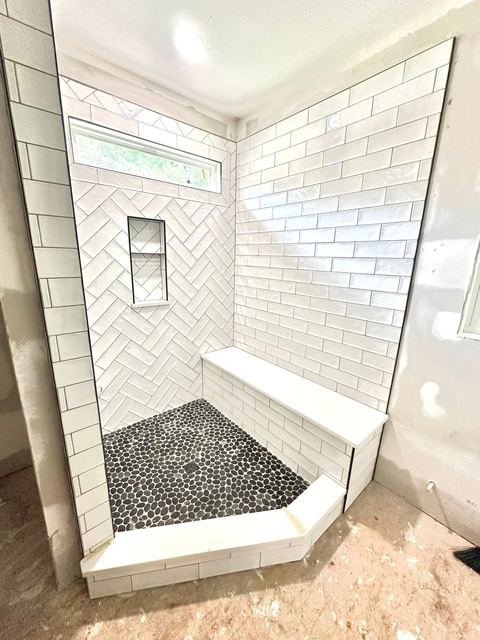 Herringbone accent, pebble floor and a tiled bench