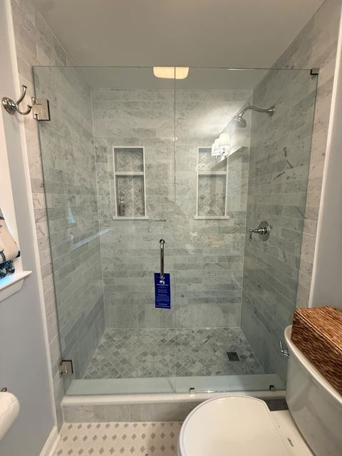 Marble shower with double niches behind glass