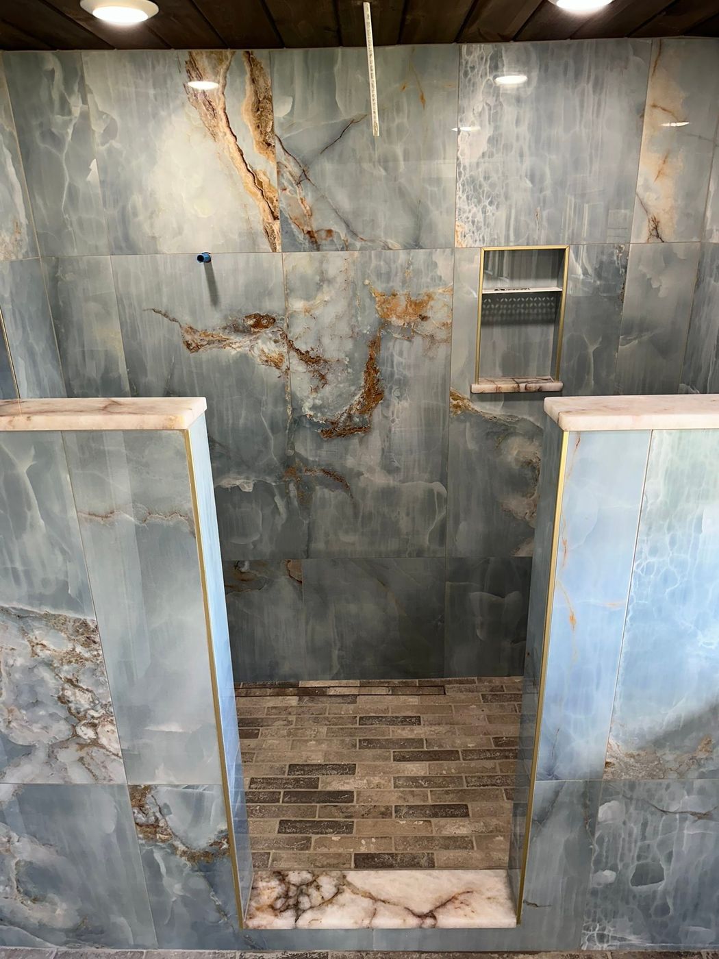 Onyx-look walk-in shower with a wood-look floor