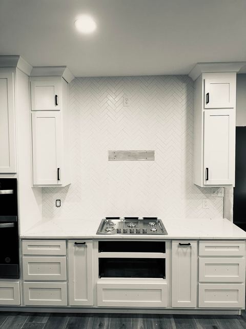 Full-height white backsplash behind the range